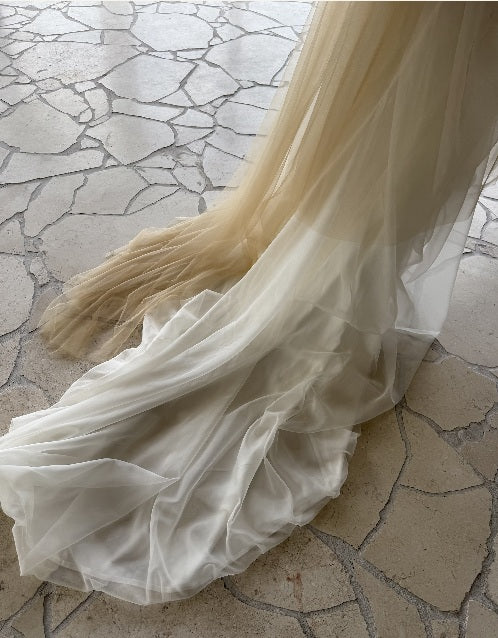 Silk tulle and organza gown train on a stone floor, cut and finished at the L'eto atelier